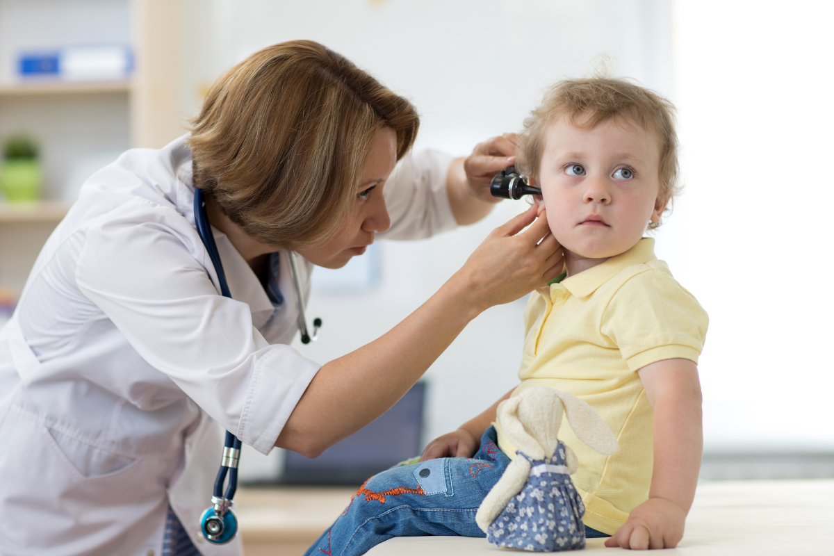 A pediatrician examining a sick child’s ear for an infection in Austin, Texas.